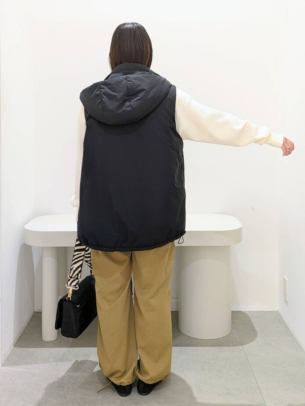 ホワイト系のニット/セーター、イエロー系のカーゴパンツ、ブラック系のその他アウターを着用したレディースの秋コーディネートの4枚目の写真