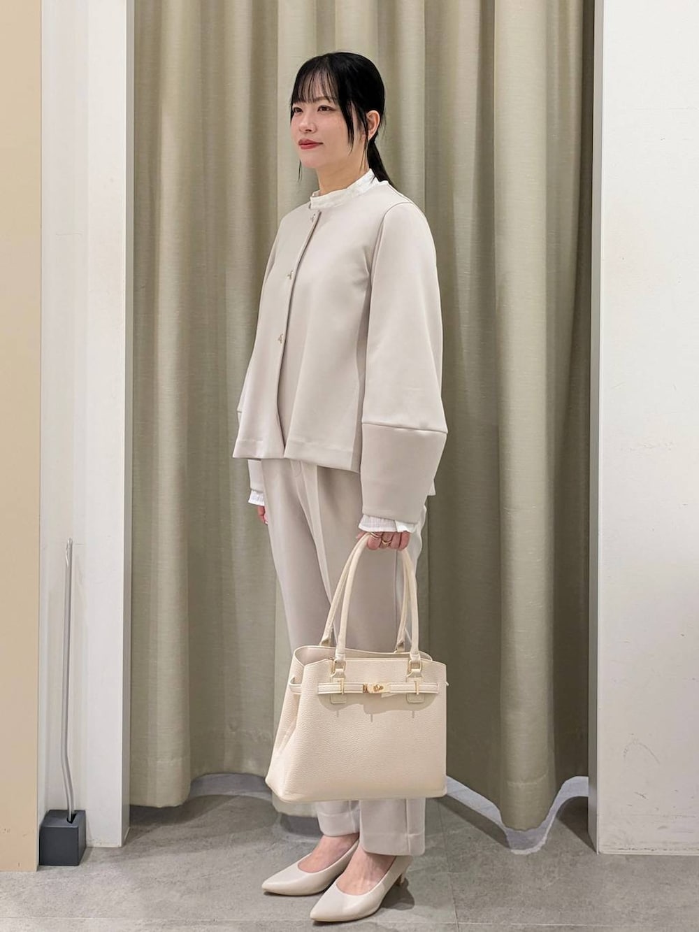 ホワイト系のパンプス、ホワイト系のシャツ/ブラウス、ベージュ系のノーカラージャケットを着用したレディースの冬コーディネートの3枚目の写真