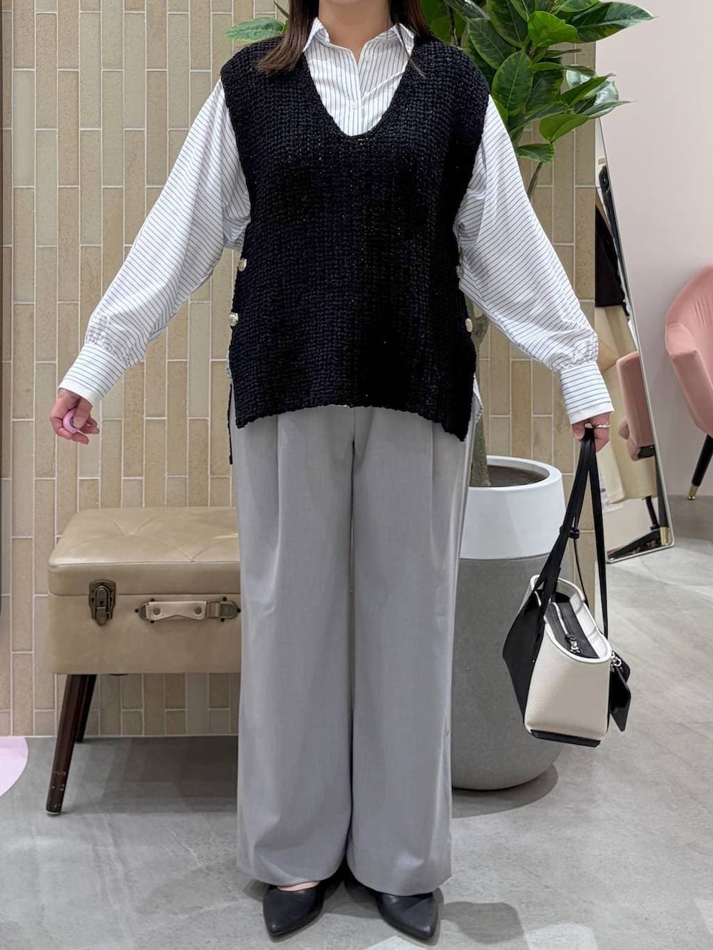 ブラック系のパンプス、ブラック系のトートバッグ、ホワイト系のシャツ/ブラウスを着用したレディースの春コーディネートの6枚目の写真