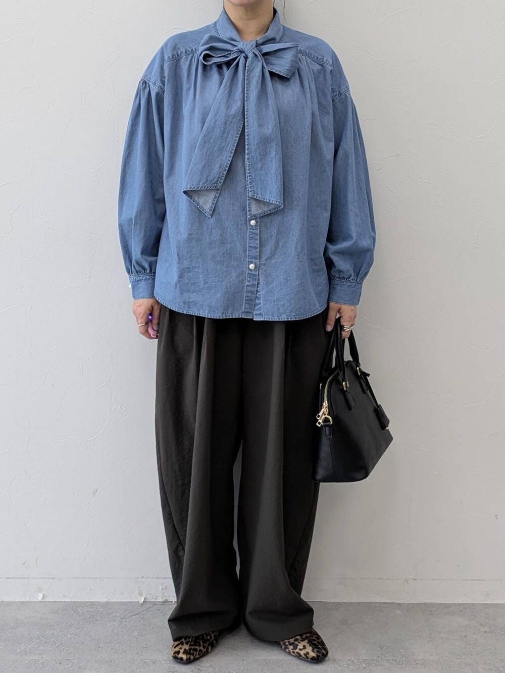 ブラック系のハンドバッグ、ブラウン系のパンプス、ブラウン系のその他パンツを着用したレディースの冬コーディネートの6枚目の写真