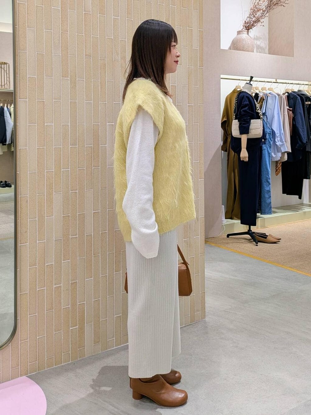 ベージュ系のスカート、ブラウン系のブーツ、ブラウン系のショルダーバッグを着用したレディースの秋コーディネートの5枚目の写真