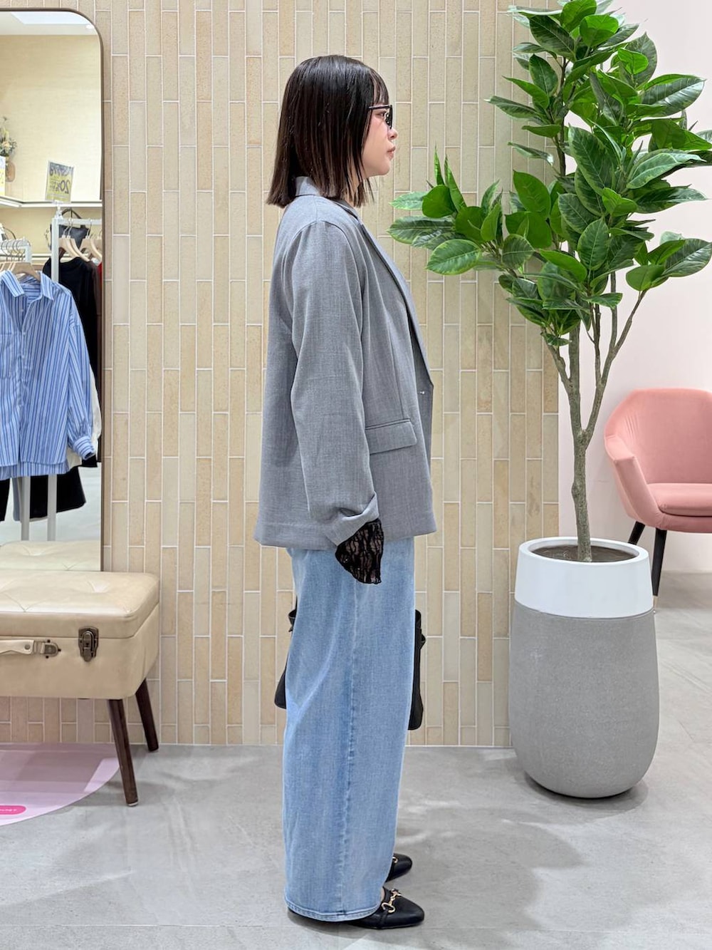 ブルー系のデニムパンツ、ブラック系のハンドバッグ、ブラック系のパンプスを着用したレディースの春コーディネートの5枚目の写真