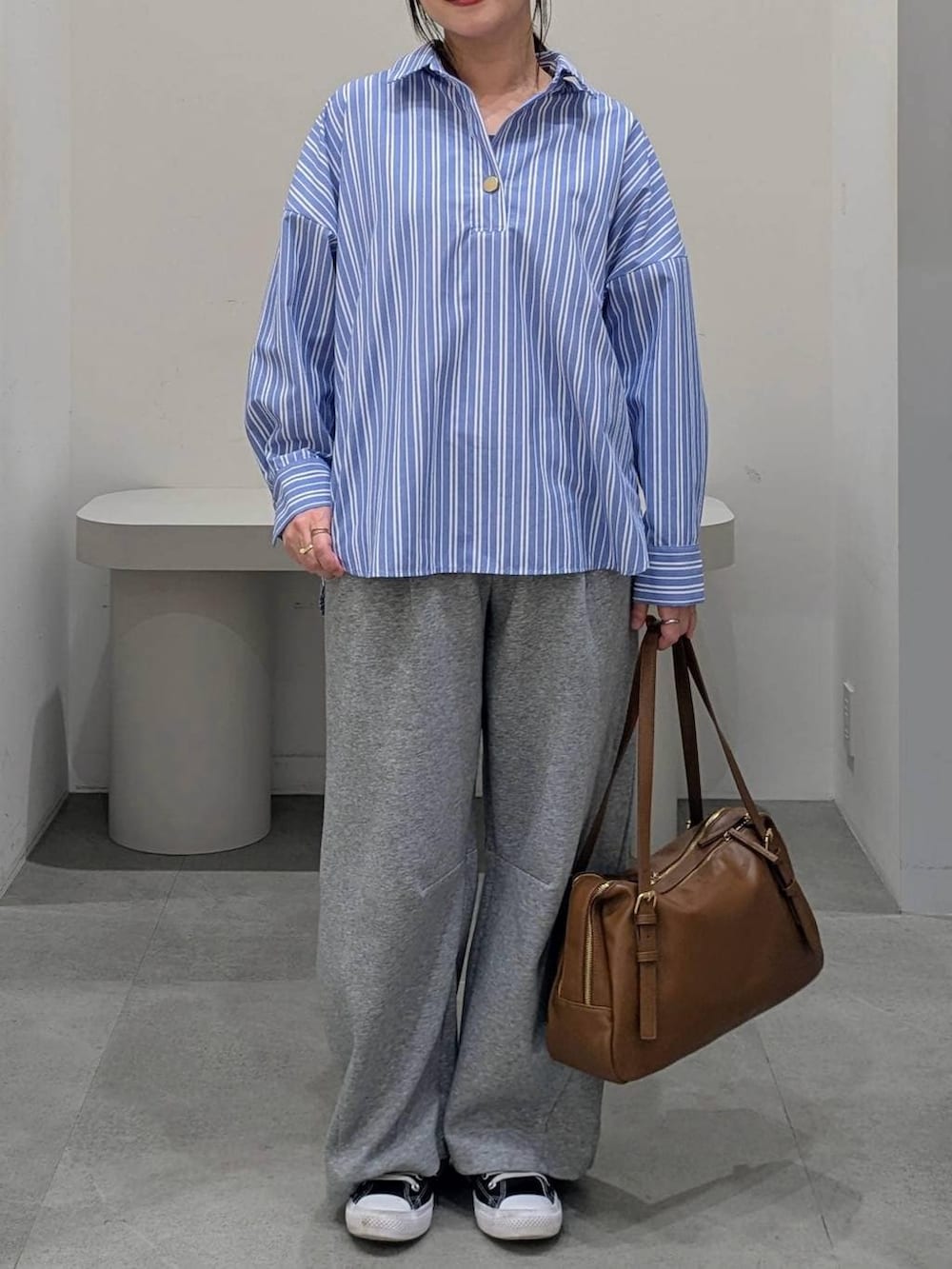 グレー系のスウェットパンツ、イエロー系のボストンバッグ、ブルー系のシャツ/ブラウスを着用したレディースの冬コーディネートの6枚目の写真