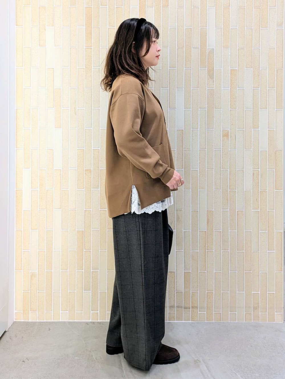 ブラウン系のカーディガン/ボレロ、グレー系のその他パンツ、ホワイト系のタンクトップを着用したレディースの秋コーディネートの5枚目の写真