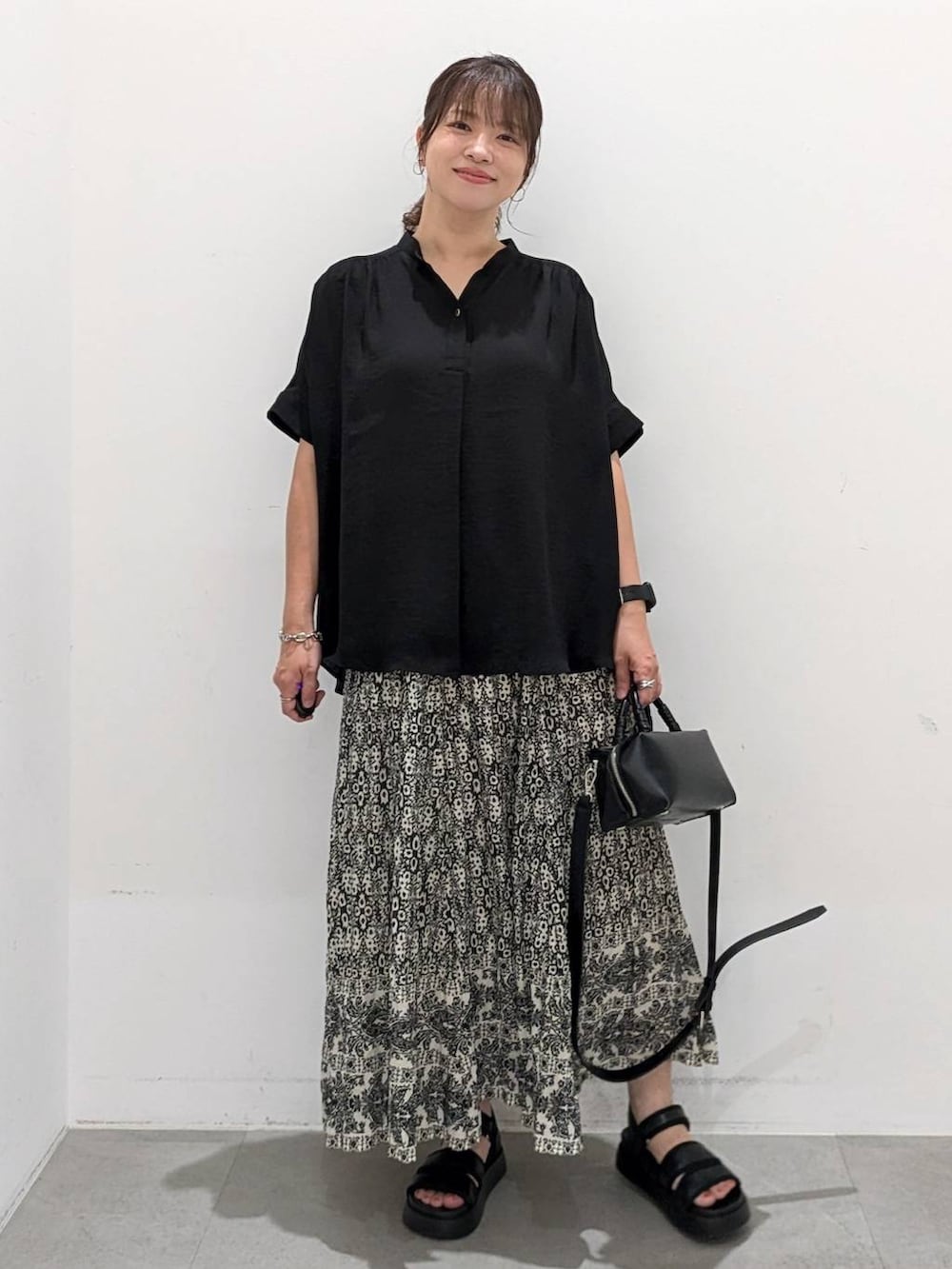 ブラック系のスカート、ブラック系のサンダル、ブラック系のTシャツ/カットソーを着用したレディースの夏コーディネートの3枚目の写真