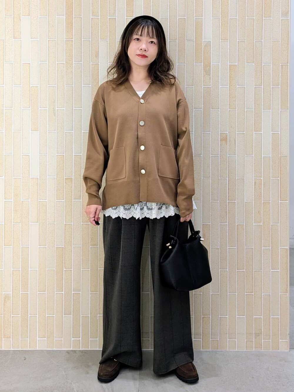 ブラウン系のカーディガン/ボレロ、グレー系のその他パンツ、ホワイト系のタンクトップを着用したレディースの秋コーディネートの2枚目の写真