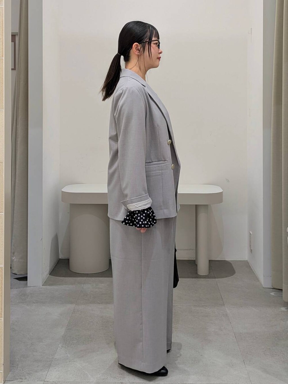 ブラック系のハンドバッグ、ブラック系のパンプス、グレー系のその他パンツを着用したレディースの冬コーディネートの5枚目の写真