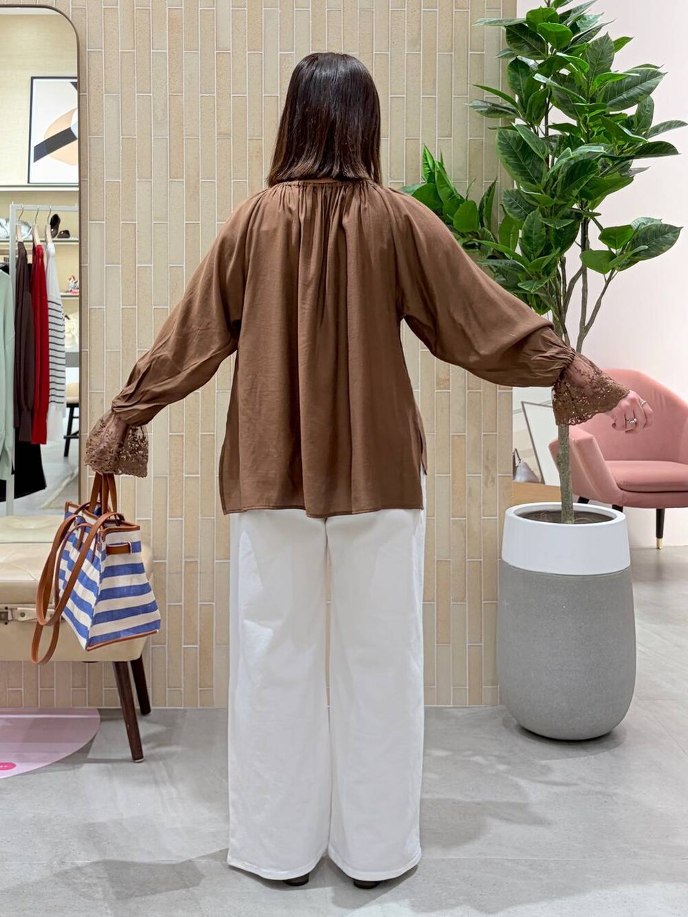 ホワイト系のデニムパンツ、ブルー系のトートバッグ、ブラウン系のパンプスを着用したレディースの春コーディネートの4枚目の写真