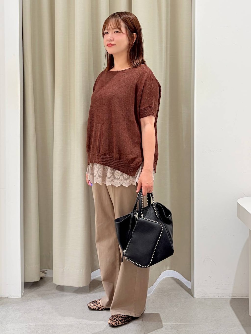 ブラウン系のパンプス、ベージュ系のタンクトップ、ブラック系のトートバッグを着用したレディースの秋コーディネートの3枚目の写真