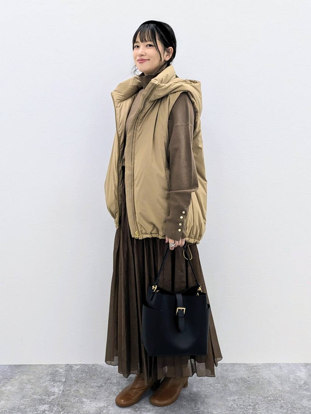 ブラウン系のブーツ、ブラック系のショルダーバッグ、ブラウン系のニット/セーターを着用したレディースの秋コーディネートの3枚目の写真