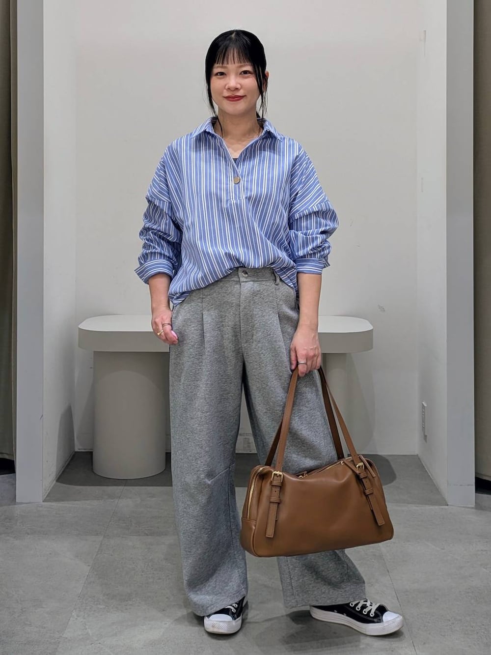 グレー系のスウェットパンツ、イエロー系のボストンバッグ、ブルー系のシャツ/ブラウスを着用したレディースの冬コーディネートの2枚目の写真