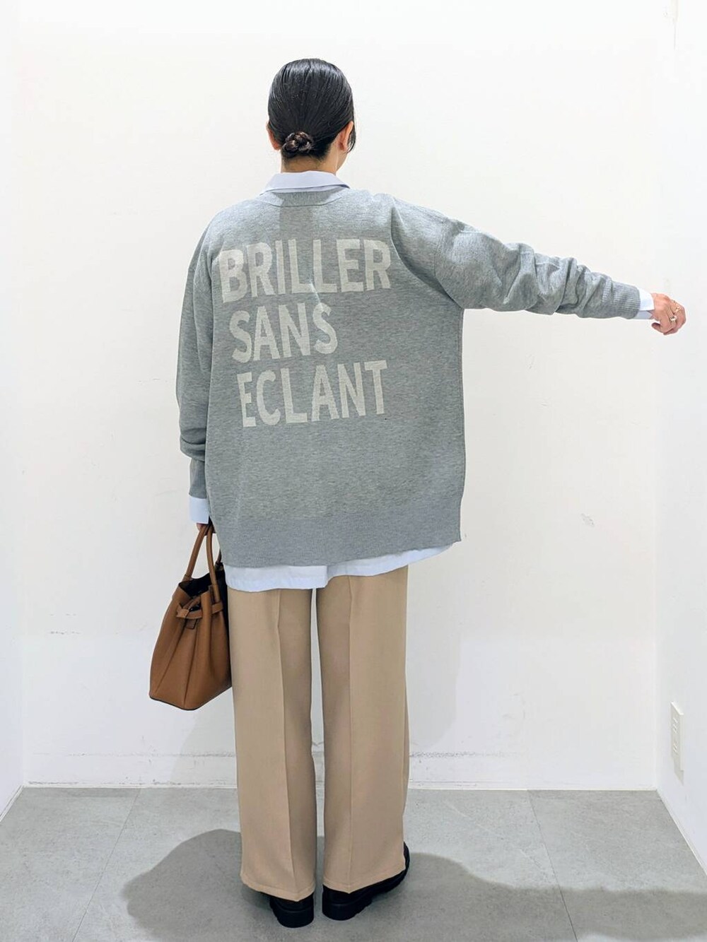 ブラウン系のハンドバッグ、ブルー系のシャツ/ブラウス、ベージュ系のその他パンツを着用したレディースの秋コーディネートの4枚目の写真