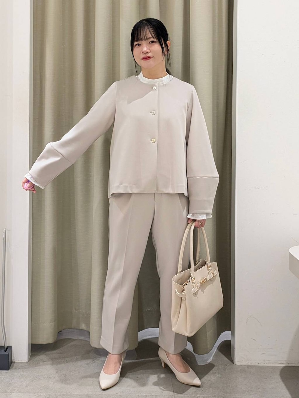 ホワイト系のパンプス、ホワイト系のシャツ/ブラウス、ベージュ系のノーカラージャケットを着用したレディースの冬コーディネートの2枚目の写真