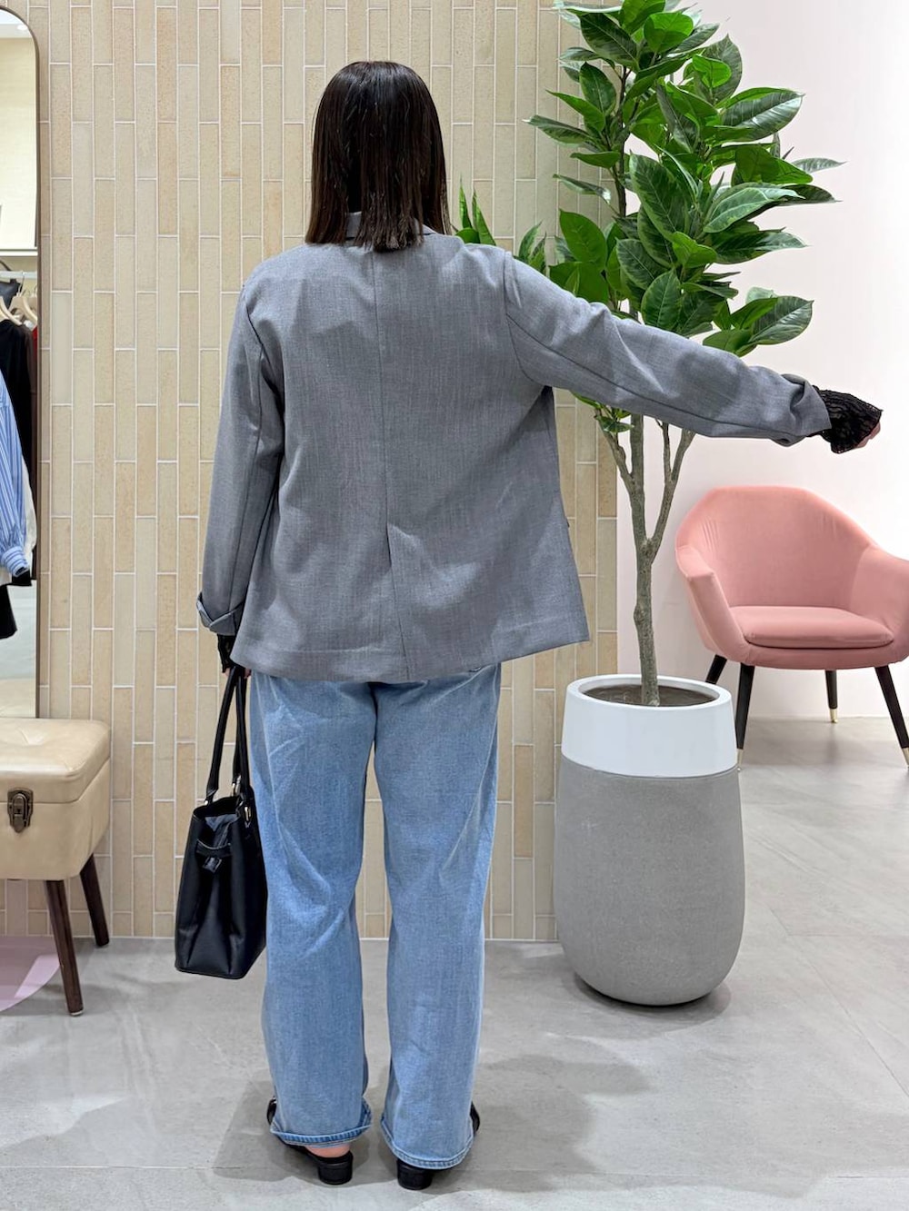 ブルー系のデニムパンツ、ブラック系のハンドバッグ、ブラック系のパンプスを着用したレディースの春コーディネートの4枚目の写真