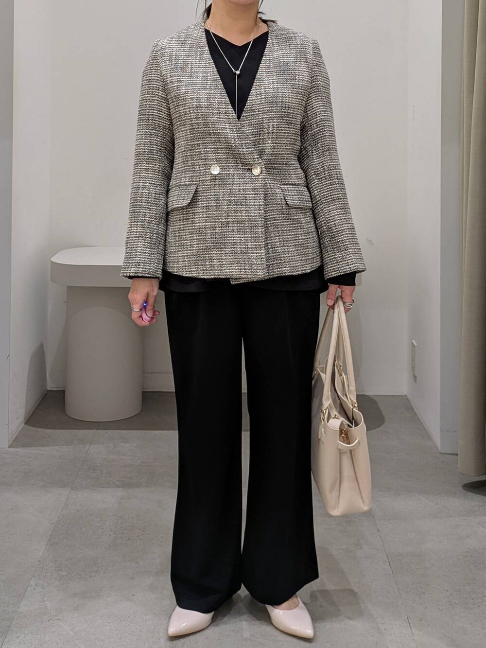 ホワイト系のパンプス、ブラック系のその他パンツ、ブラック系のノーカラージャケットを着用したレディースの冬コーディネートの7枚目の写真