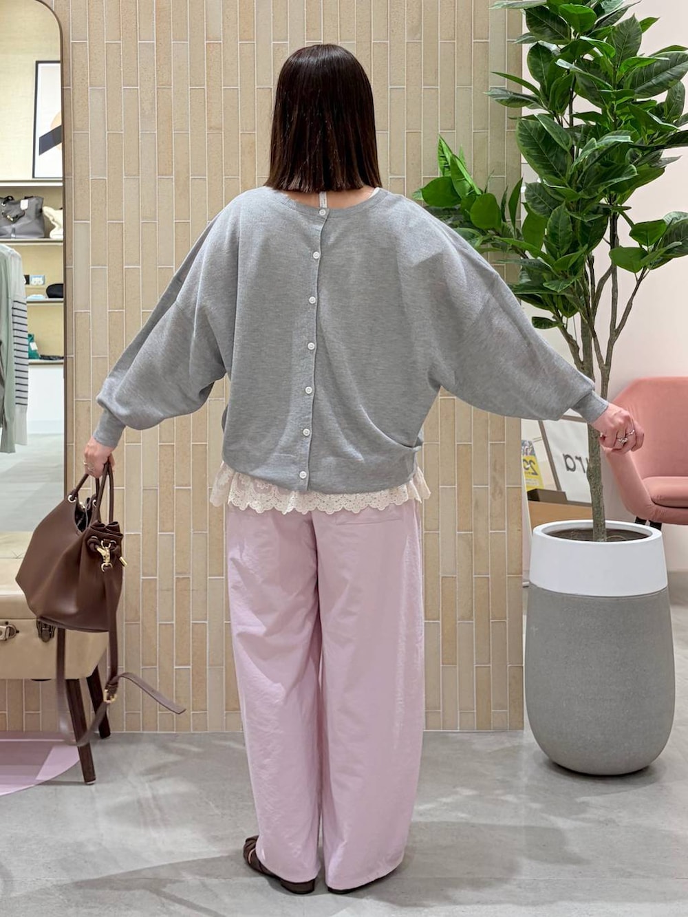 ホワイト系のタンクトップ、ピンク系のその他パンツ、ブラウン系のハンドバッグを着用したレディースの春コーディネートの4枚目の写真