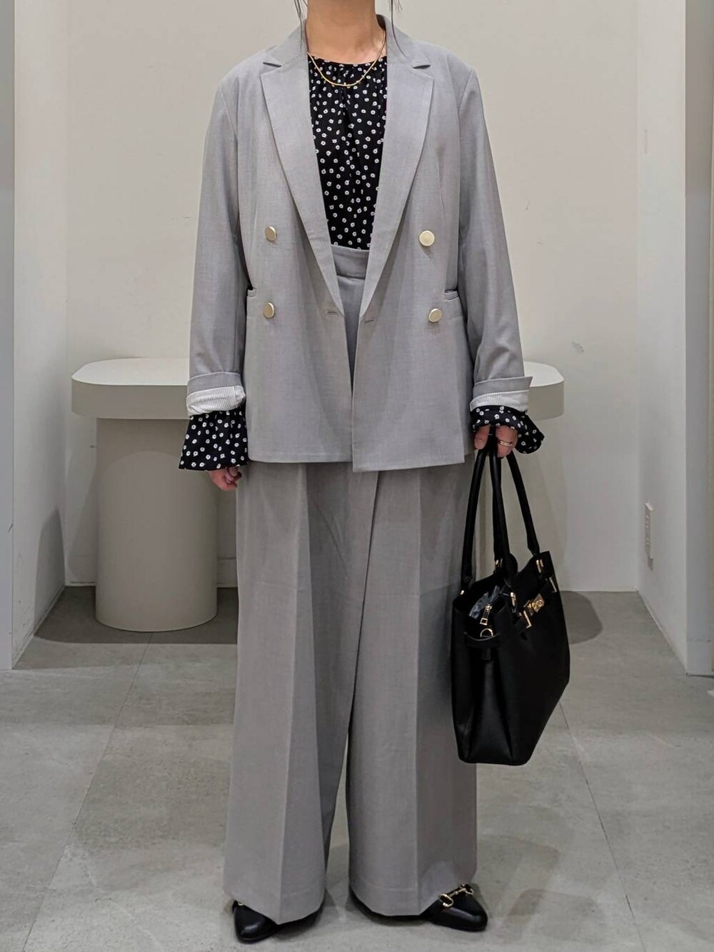 ブラック系のハンドバッグ、ブラック系のパンプス、グレー系のその他パンツを着用したレディースの冬コーディネートの6枚目の写真