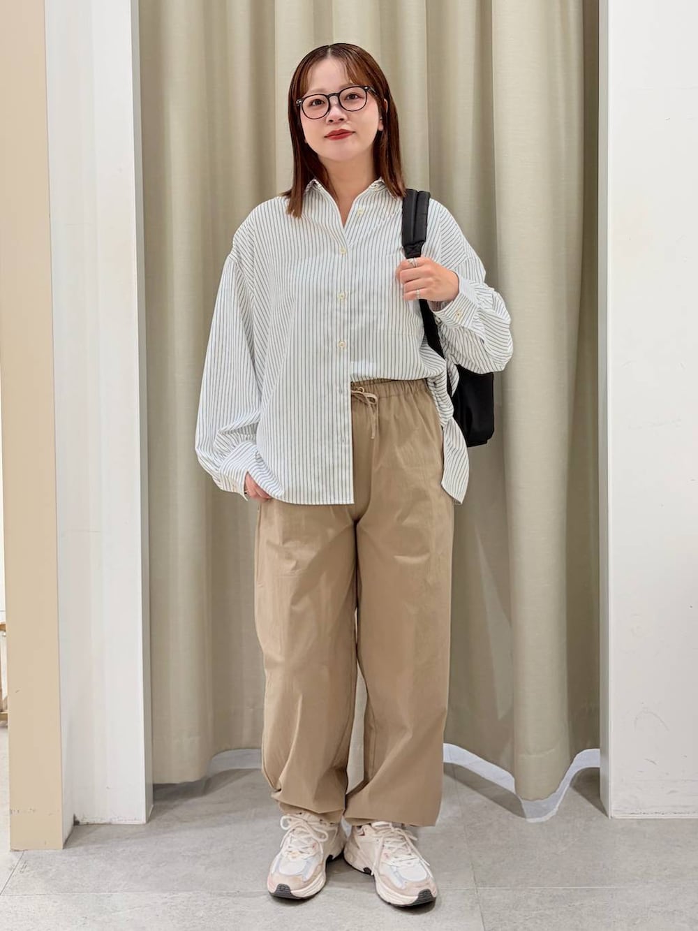 グリーン系のその他パンツ、ブラック系のバックパック/リュック、ブルー系のシャツ/ブラウスを着用したレディースの秋コーディネートの2枚目の写真