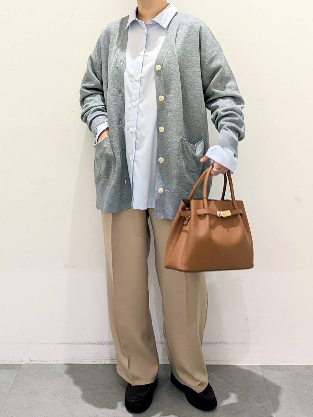ブラウン系のハンドバッグ、ブルー系のシャツ/ブラウス、ベージュ系のその他パンツを着用したレディースの秋コーディネートの6枚目の写真