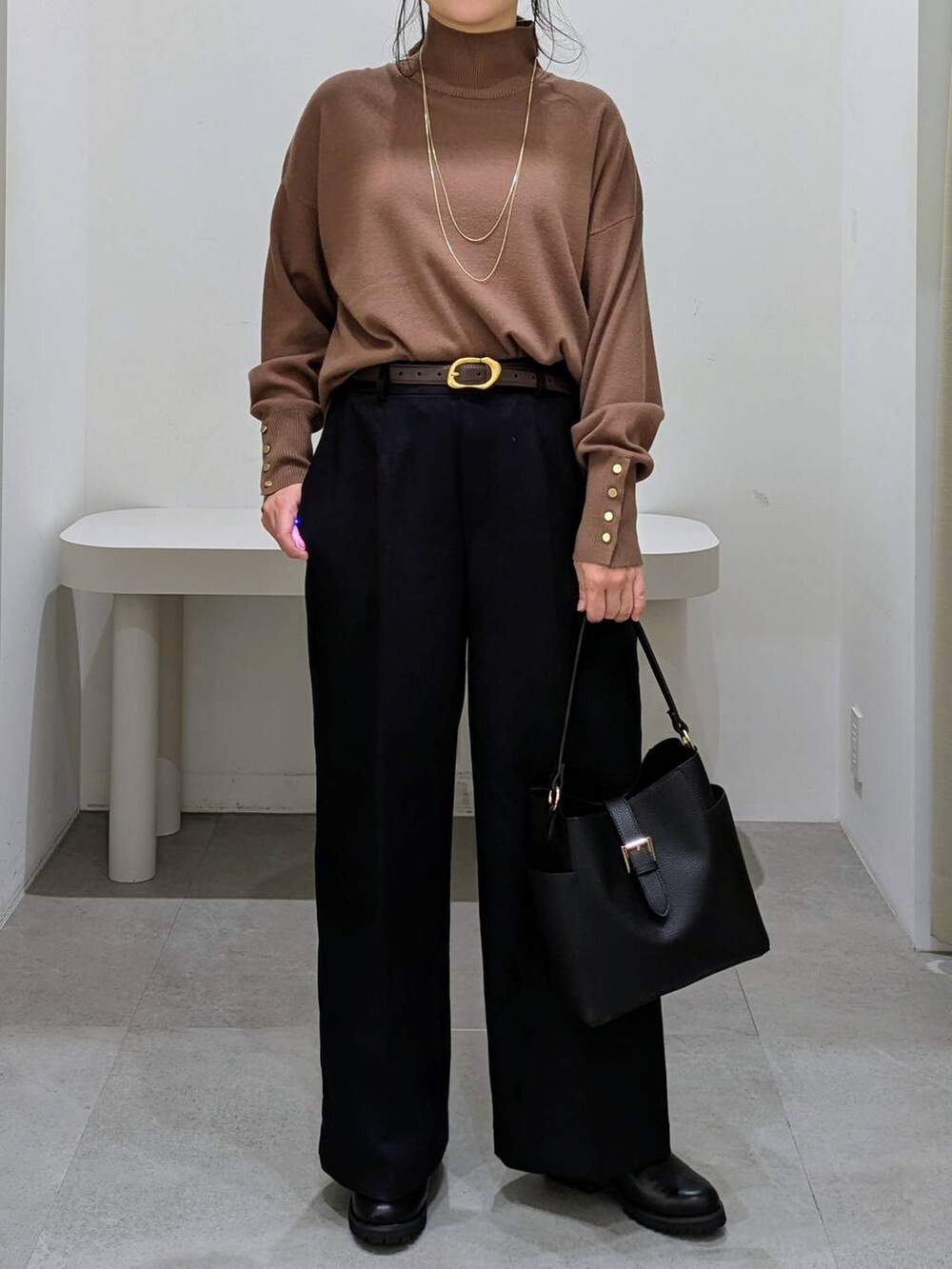 ブラック系のブーツ、ブラック系のショルダーバッグ、ブラウン系のニット/セーターを着用したレディースの秋コーディネートの6枚目の写真