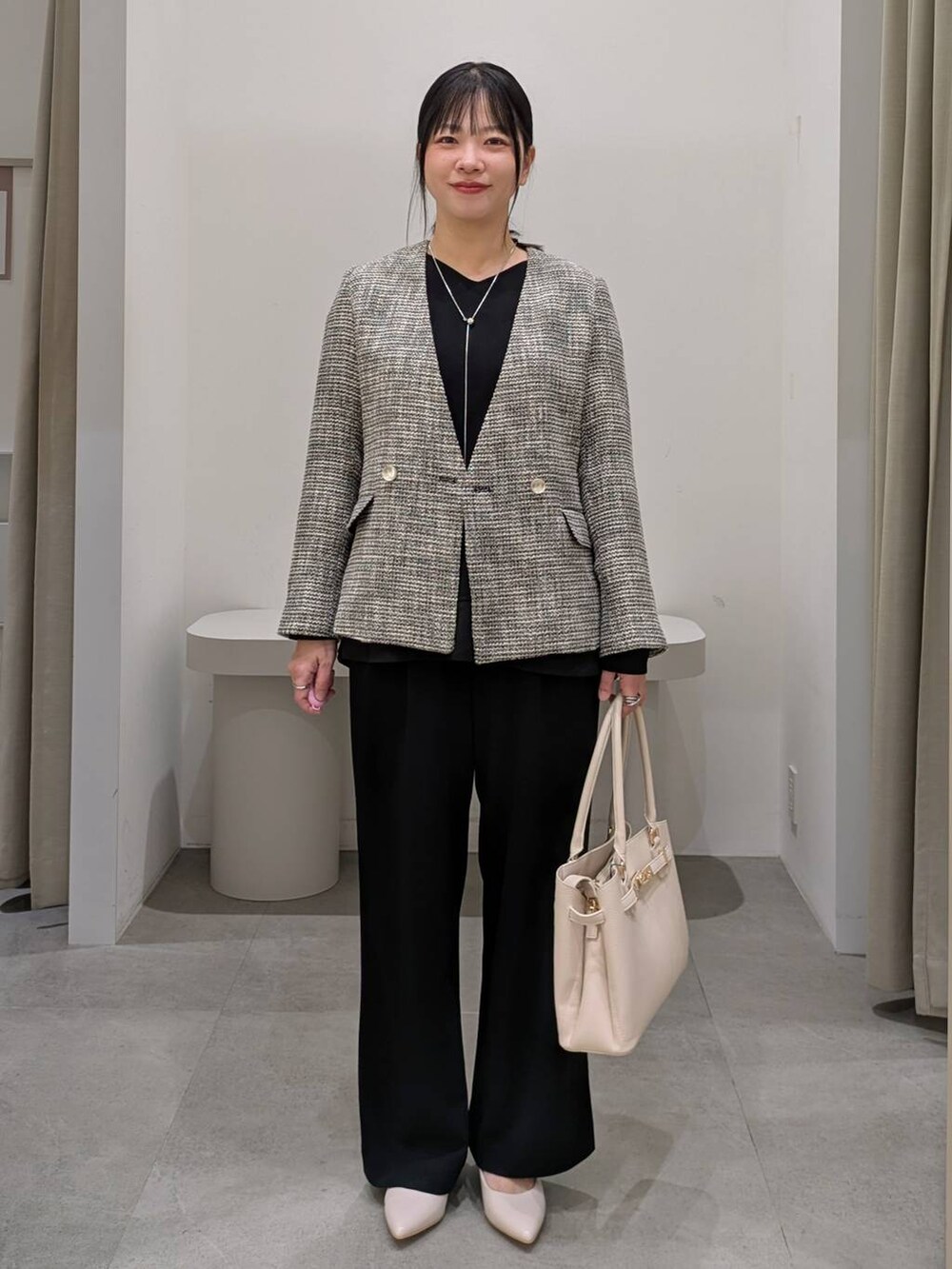 ホワイト系のパンプス、ブラック系のその他パンツ、ブラック系のノーカラージャケットを着用したレディースの冬コーディネートの2枚目の写真