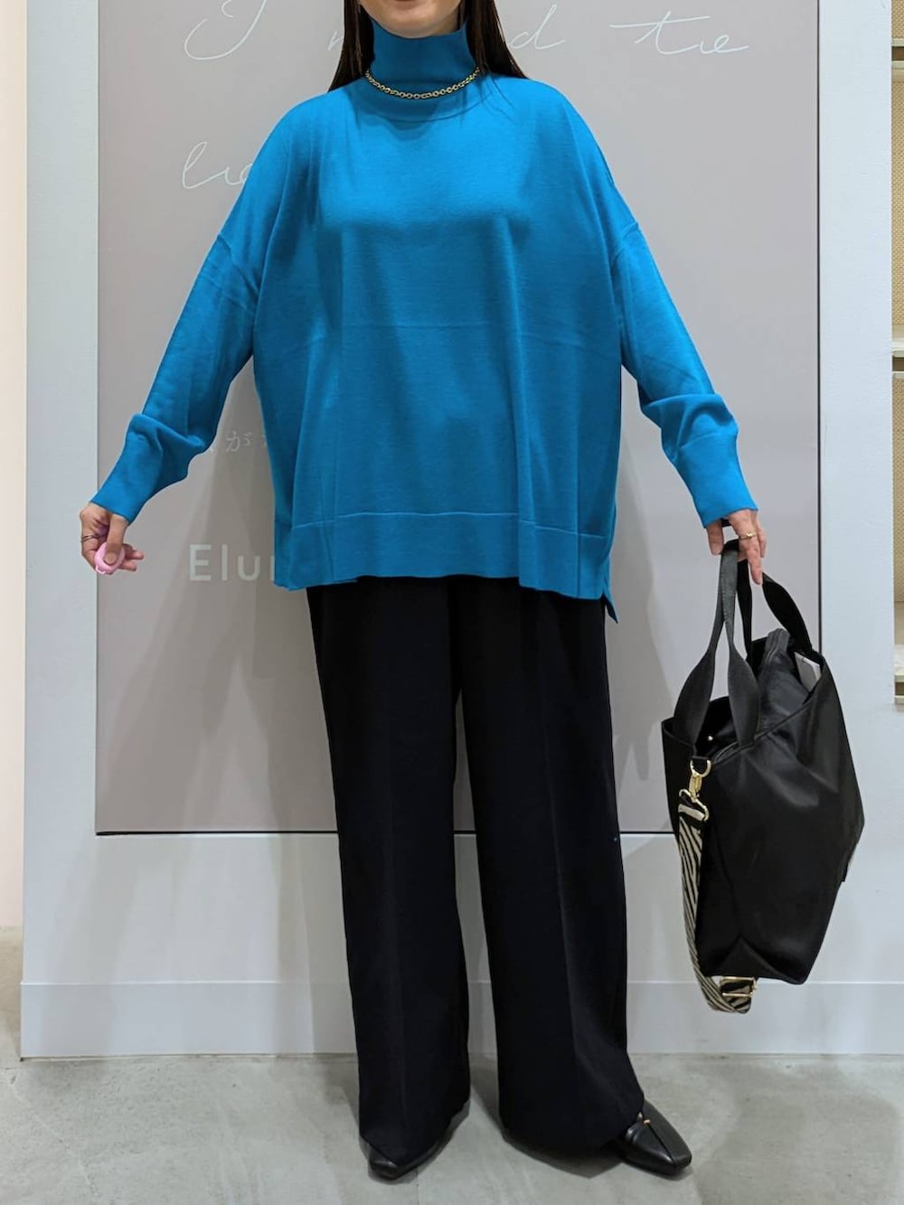 ブラック系のトートバッグ、ブルー系のその他パンツ、ブラック系のパンプスを着用したレディースの冬コーディネートの6枚目の写真