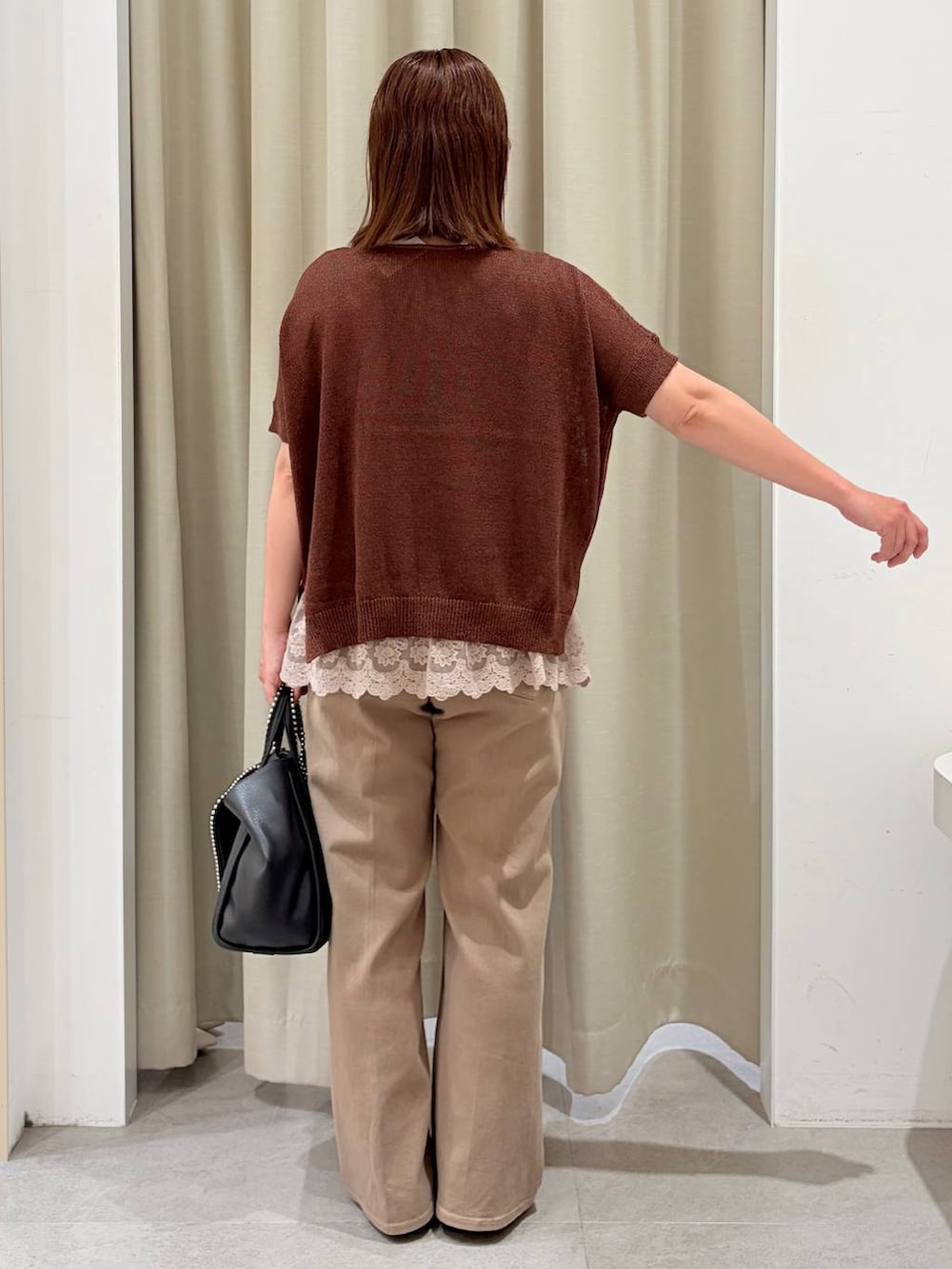 ブラウン系のパンプス、ベージュ系のタンクトップ、ブラック系のトートバッグを着用したレディースの秋コーディネートの4枚目の写真