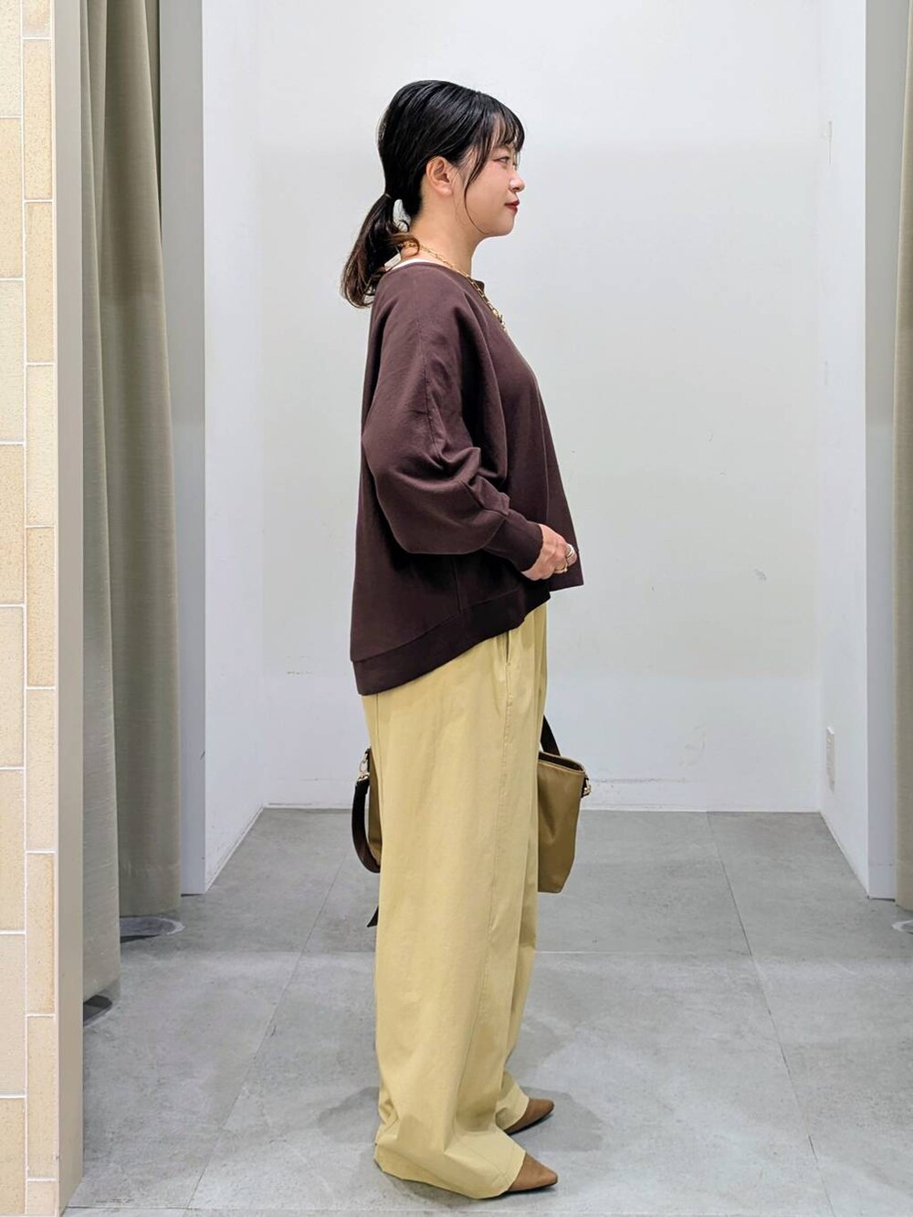 ブラウン系のパンプス、ベージュ系のハンドバッグ、ブラウン系のニット/セーターを着用したレディースの秋コーディネートの5枚目の写真