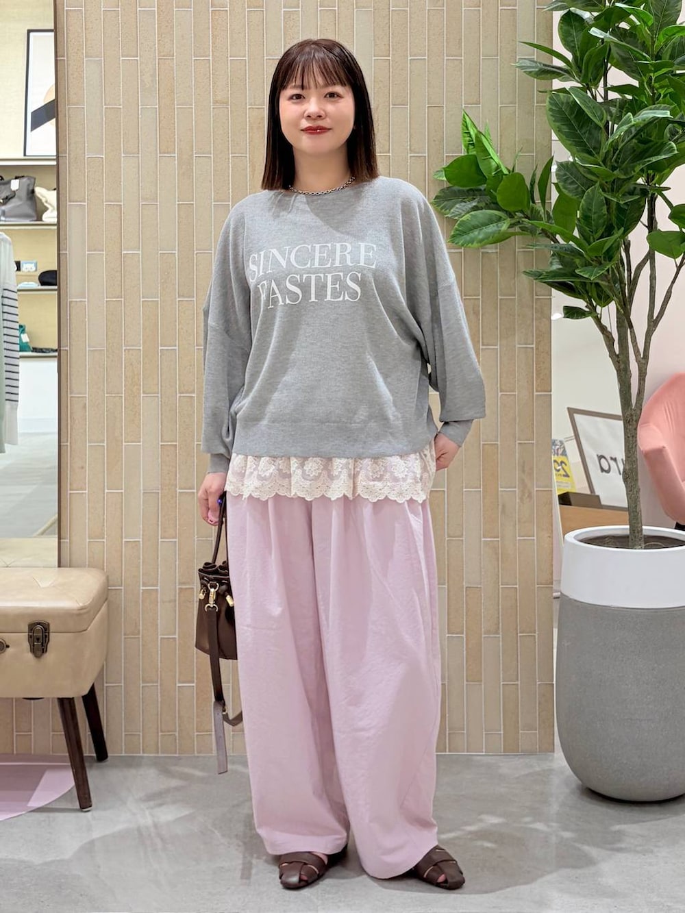 ホワイト系のタンクトップ、ピンク系のその他パンツ、ブラウン系のハンドバッグを着用したレディースの春コーディネートの2枚目の写真