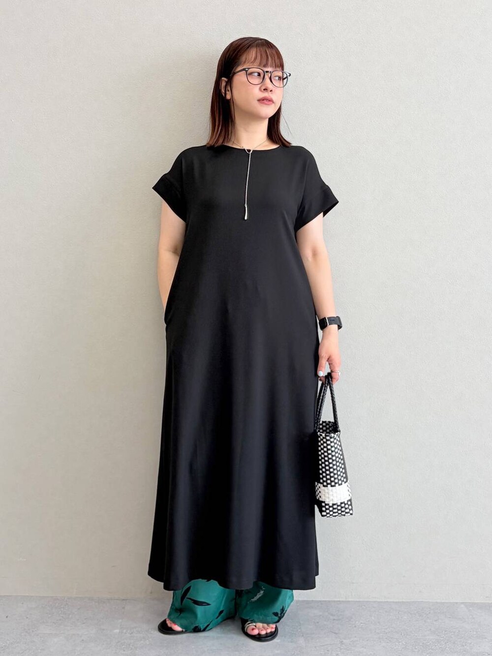 グリーン系のその他パンツ、ブラック系のかごバッグを着用したレディースの夏コーディネートの2枚目の写真