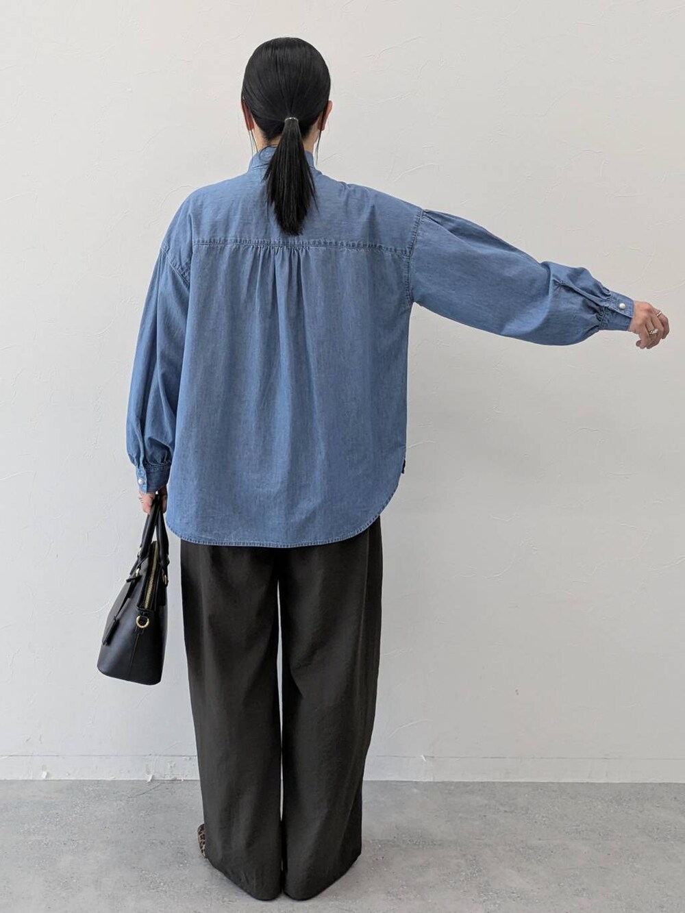 ブラック系のハンドバッグ、ブラウン系のパンプス、ブラウン系のその他パンツを着用したレディースの冬コーディネートの4枚目の写真