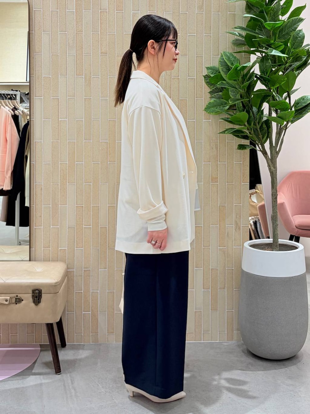 ホワイト系のパンプス、ブルー系のスラックス、ホワイト系のハンドバッグを着用したレディースの春コーディネートの5枚目の写真