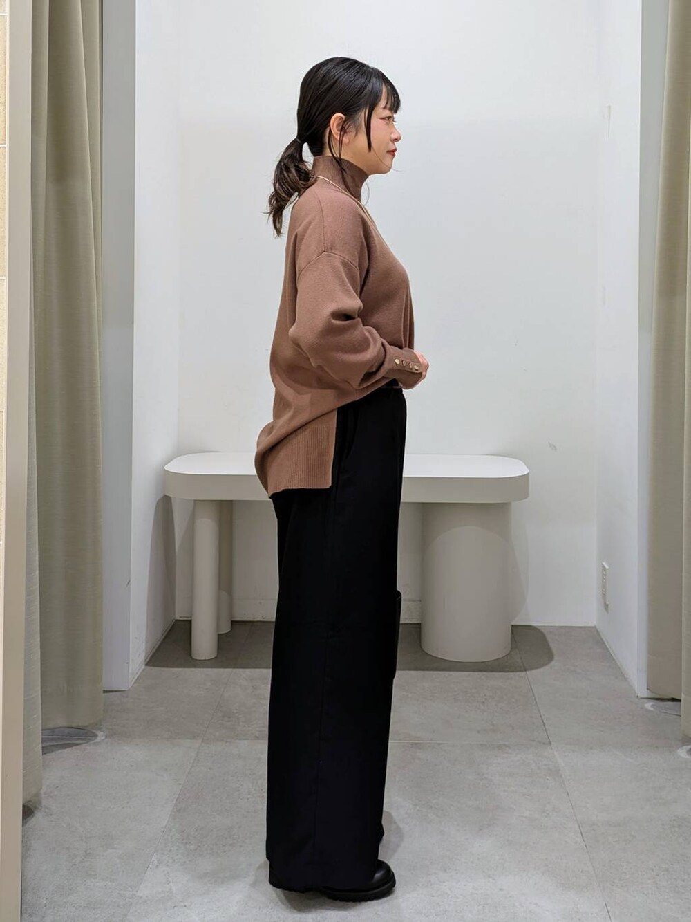 ブラック系のブーツ、ブラック系のショルダーバッグ、ブラウン系のニット/セーターを着用したレディースの秋コーディネートの5枚目の写真