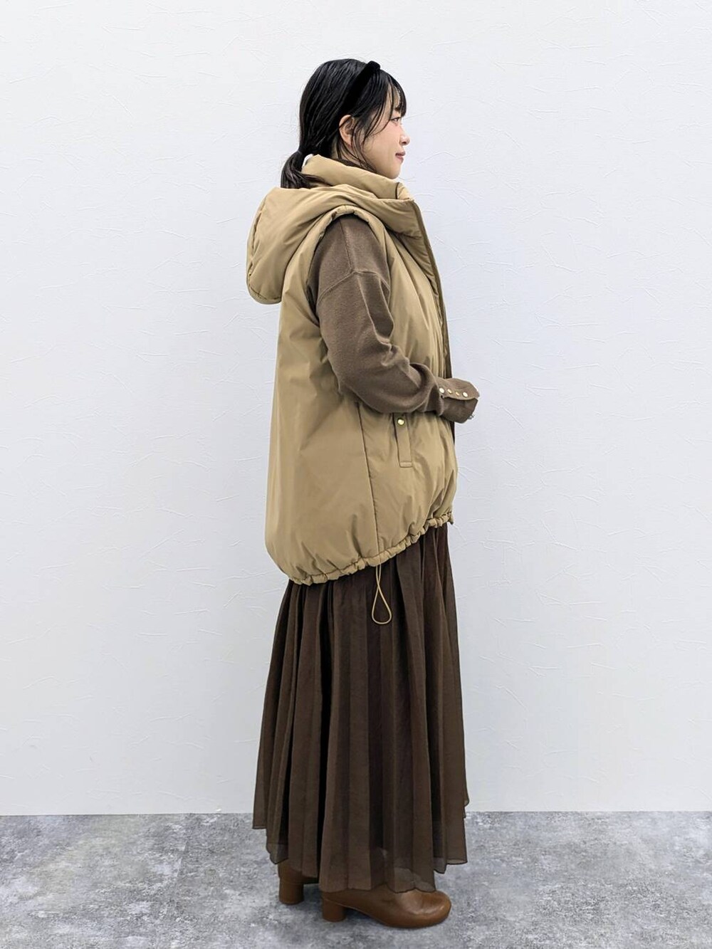 ブラウン系のブーツ、ブラック系のショルダーバッグ、ブラウン系のニット/セーターを着用したレディースの秋コーディネートの5枚目の写真