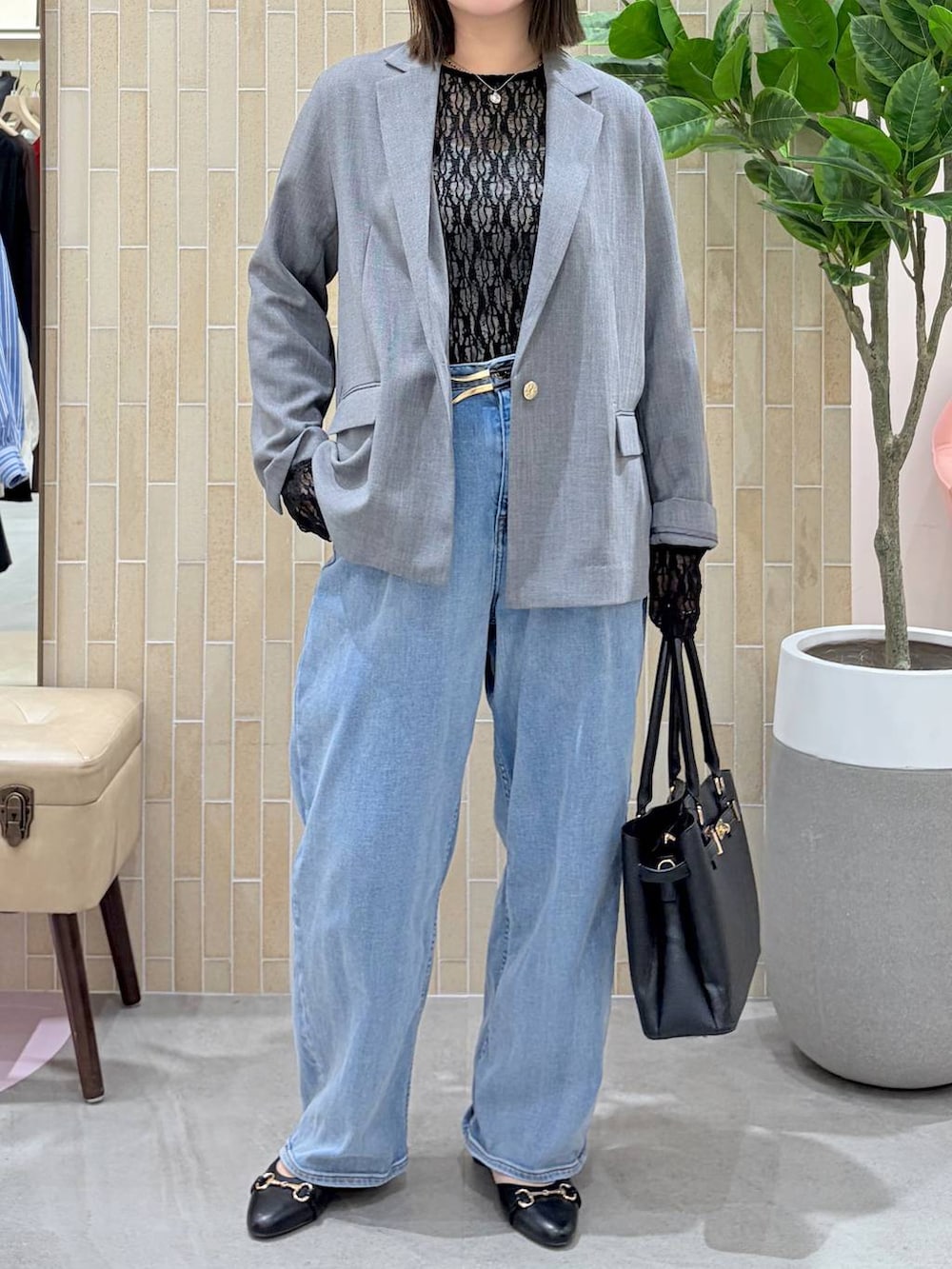 ブルー系のデニムパンツ、ブラック系のハンドバッグ、ブラック系のパンプスを着用したレディースの春コーディネートの6枚目の写真