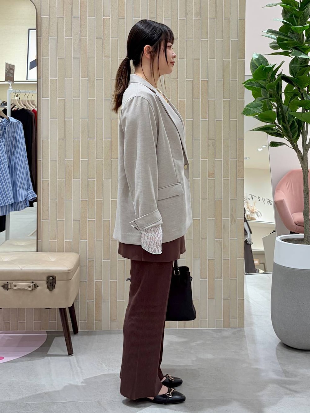 ブラック系のハンドバッグ、ブラック系のパンプス、ブラウン系のその他パンツを着用したレディースの春コーディネートの5枚目の写真