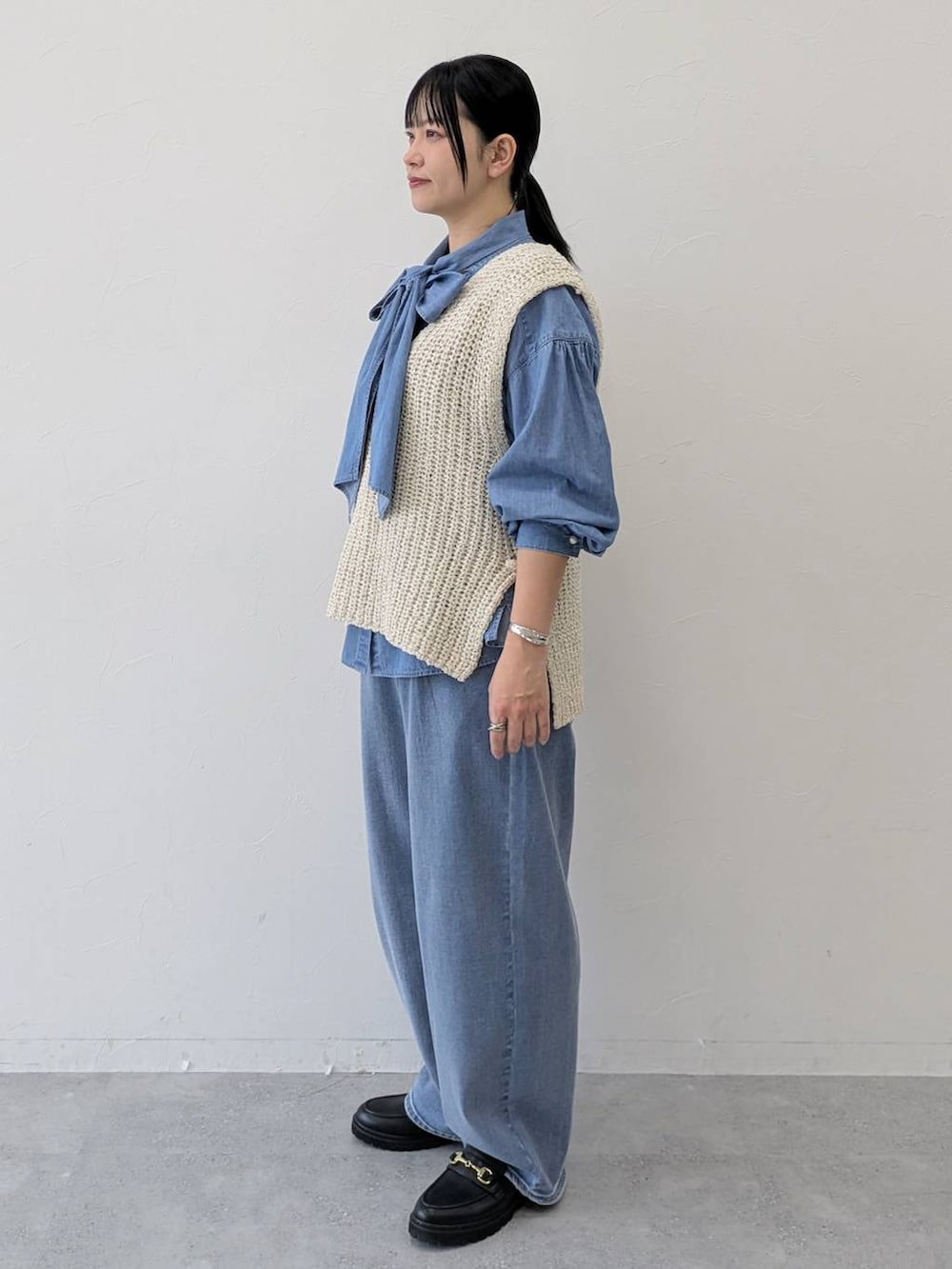 ブルー系のデニムパンツ、ブラック系のローファー、ブルー系のシャツ/ブラウスを着用したレディースの冬コーディネートの3枚目の写真