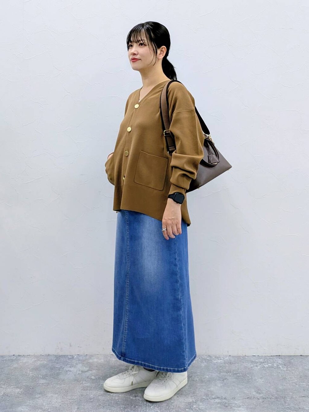 ブラウン系のカーディガン/ボレロ、ブルー系のデニムスカートを着用したレディースの夏コーディネートの3枚目の写真