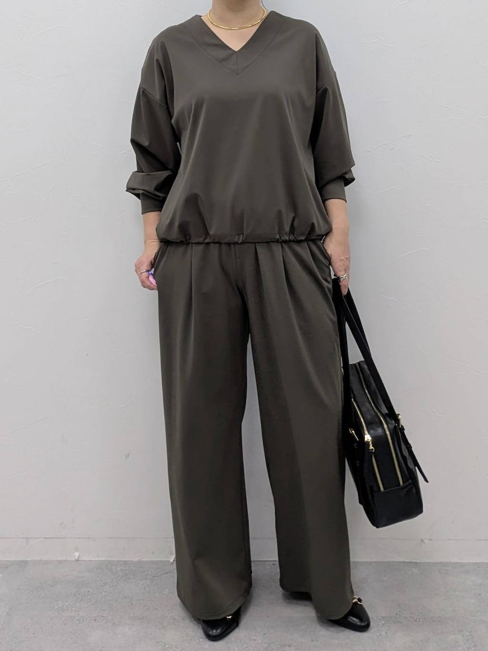 ブラック系のボストンバッグ、ブラック系のパンプス、グリーン系のその他パンツを着用したレディースの冬コーディネートの6枚目の写真