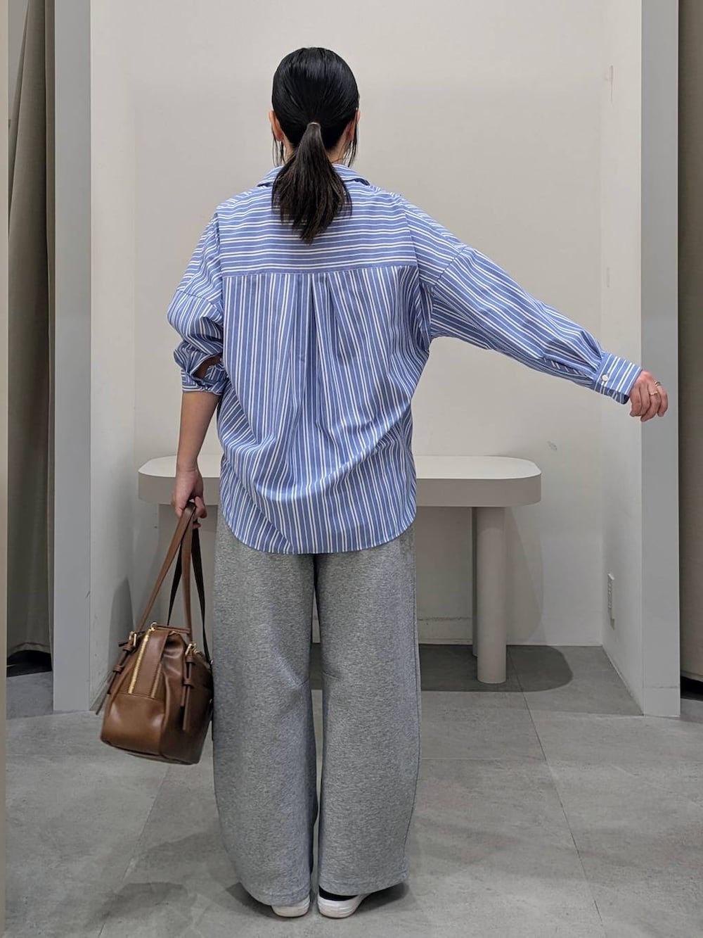 グレー系のスウェットパンツ、イエロー系のボストンバッグ、ブルー系のシャツ/ブラウスを着用したレディースの冬コーディネートの4枚目の写真