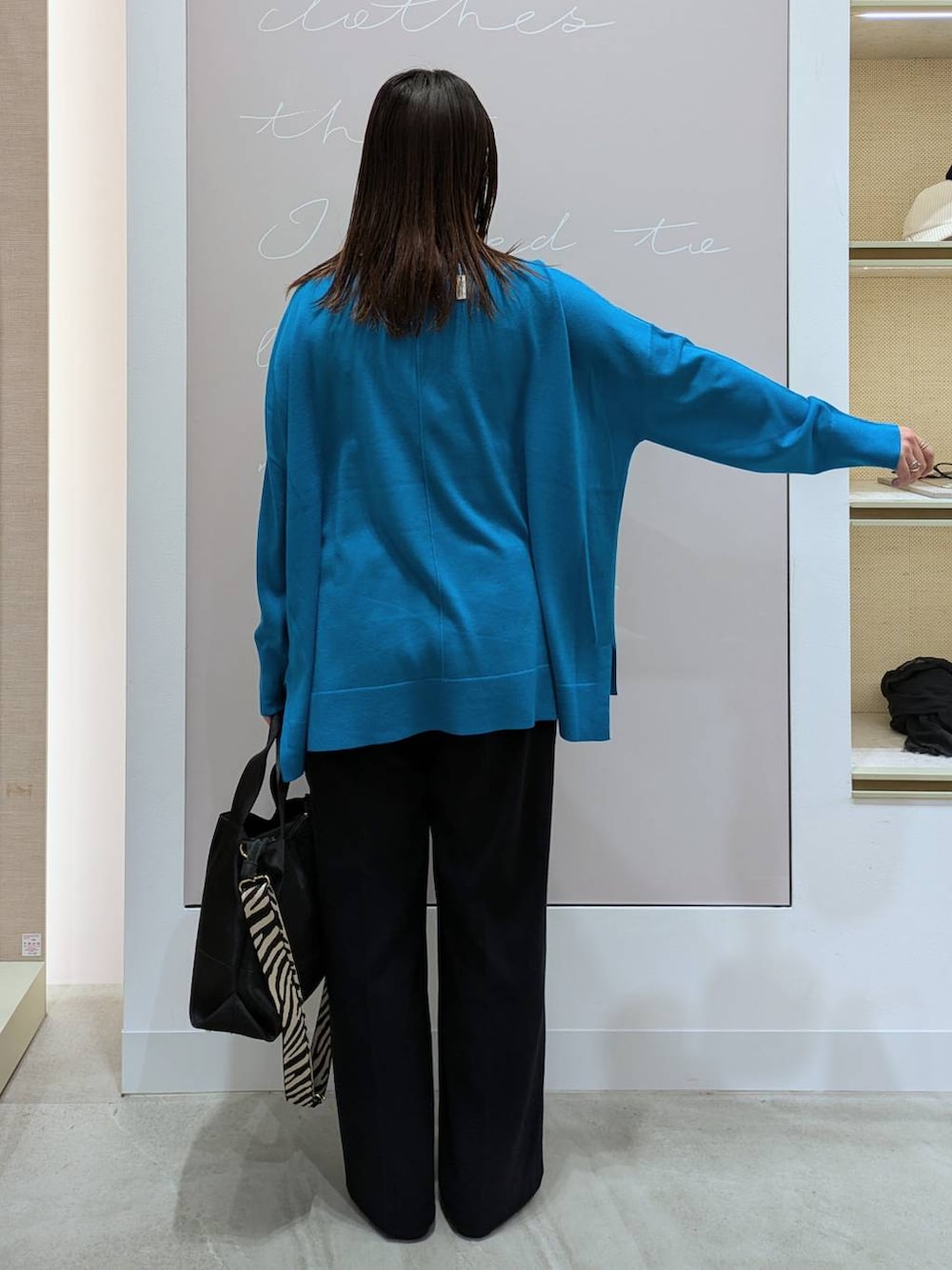 ブラック系のトートバッグ、ブルー系のその他パンツ、ブラック系のパンプスを着用したレディースの冬コーディネートの4枚目の写真