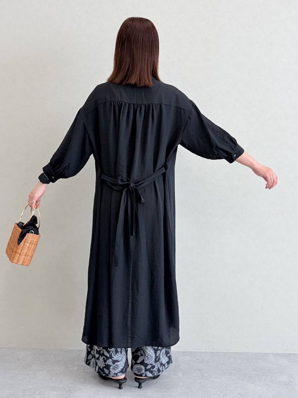 ブラウン系のかごバッグ、ブラック系のその他パンツ、ホワイト系のタンクトップを着用したレディースの夏コーディネートの4枚目の写真