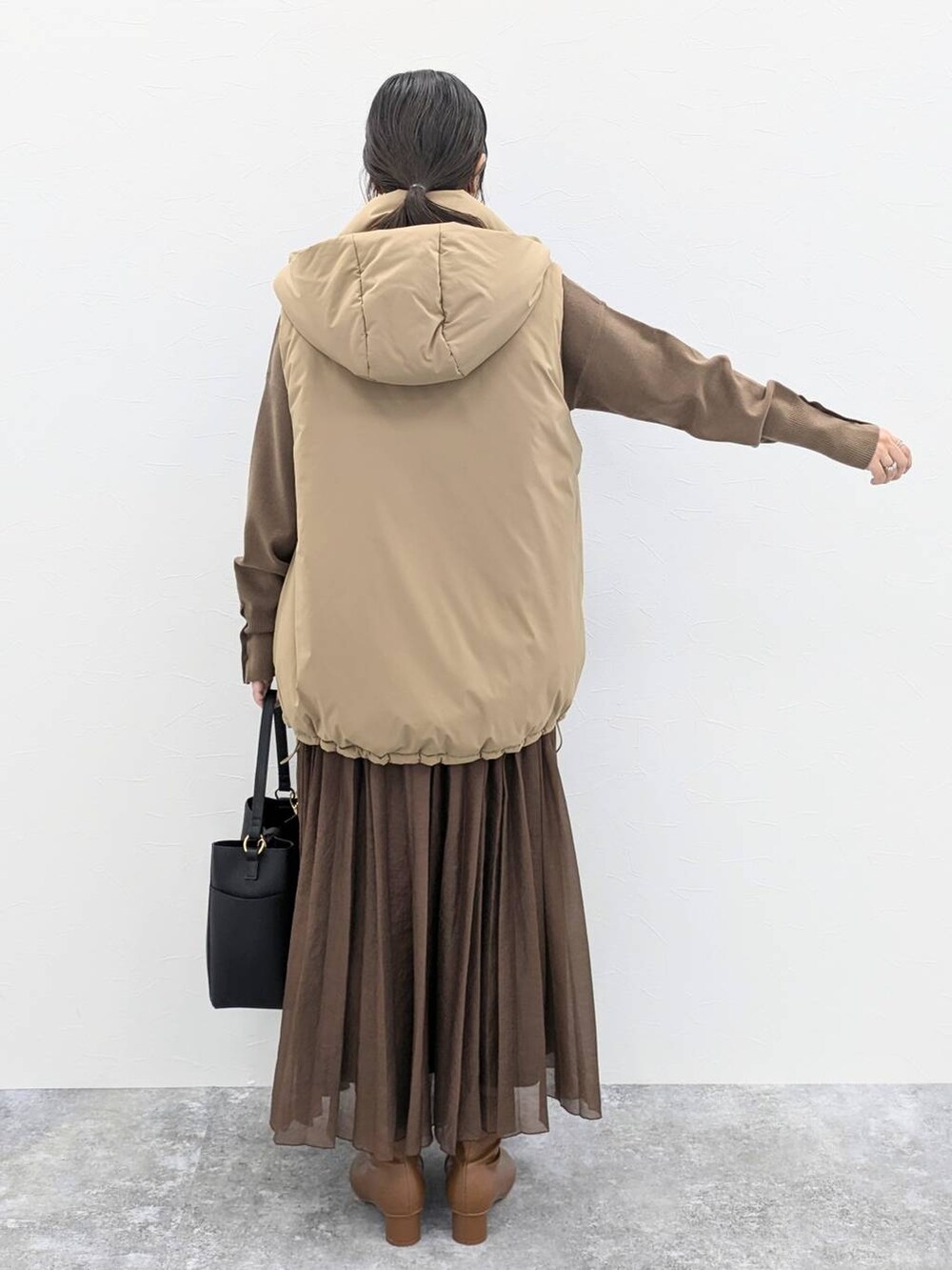 ブラウン系のブーツ、ブラック系のショルダーバッグ、ブラウン系のニット/セーターを着用したレディースの秋コーディネートの4枚目の写真