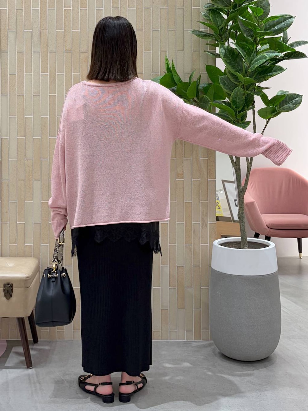 ブラック系のキャミソール、ブラック系のパンプス、ブラック系のスカートを着用したレディースの春コーディネートの4枚目の写真