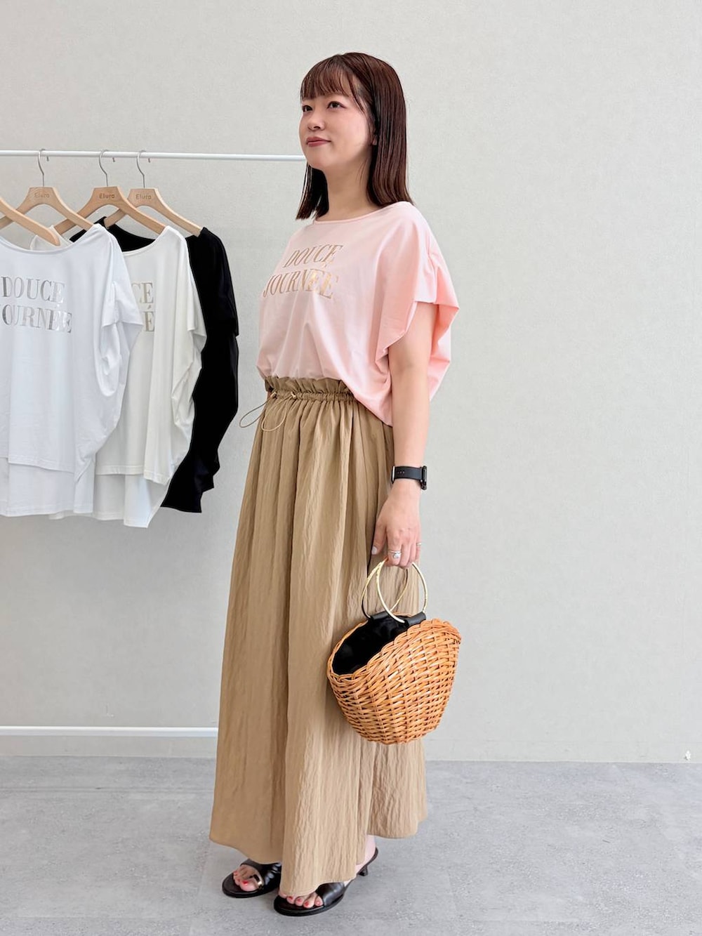 ブラウン系のかごバッグ、ピンク系のTシャツ/カットソーを着用したレディースの夏コーディネートの3枚目の写真