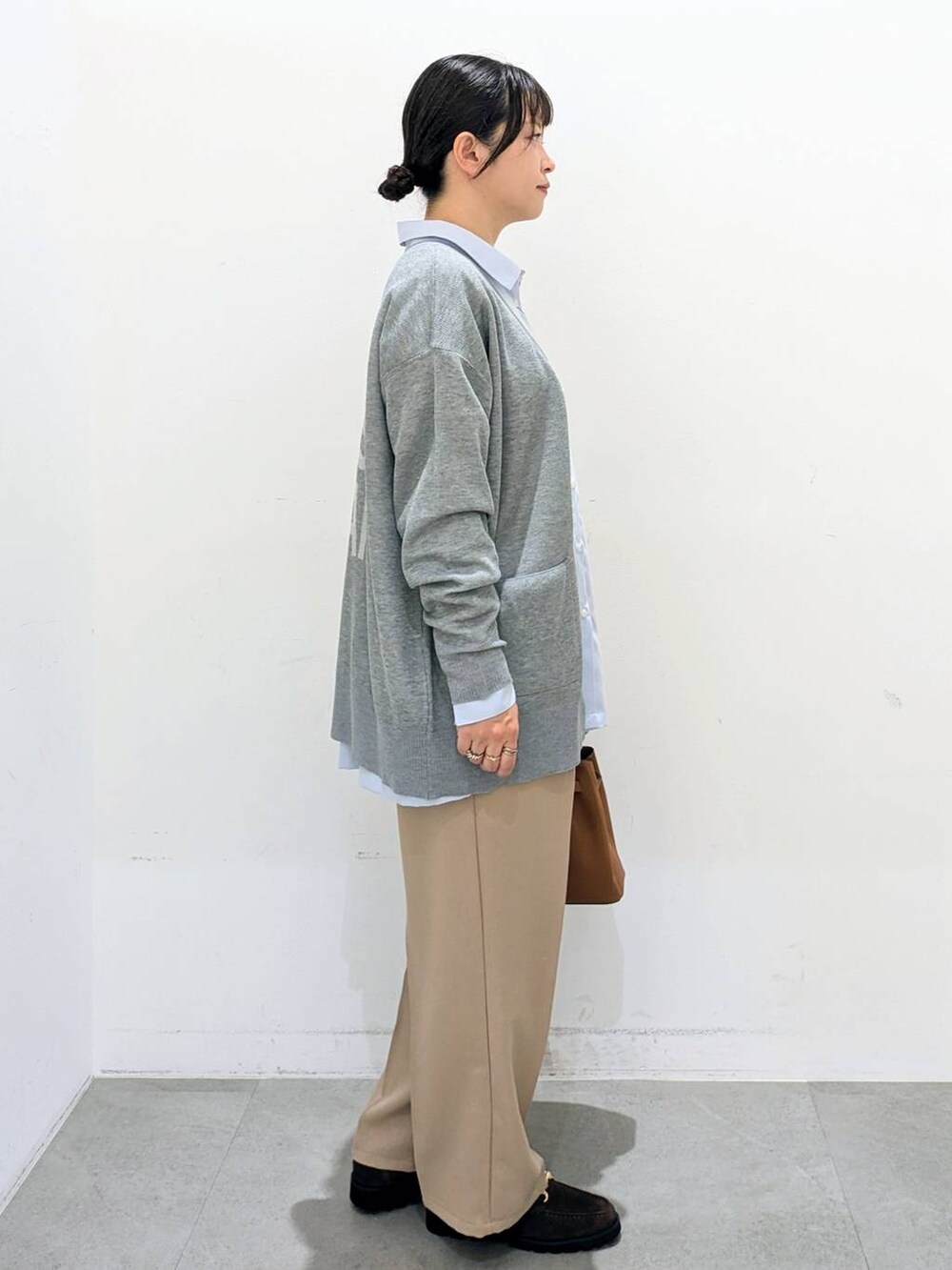 ブラウン系のハンドバッグ、ブルー系のシャツ/ブラウス、ベージュ系のその他パンツを着用したレディースの秋コーディネートの5枚目の写真