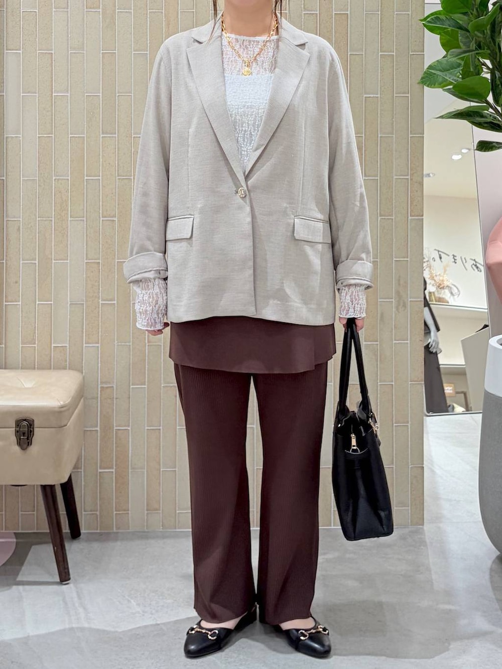 ブラック系のハンドバッグ、ブラック系のパンプス、ブラウン系のその他パンツを着用したレディースの春コーディネートの6枚目の写真