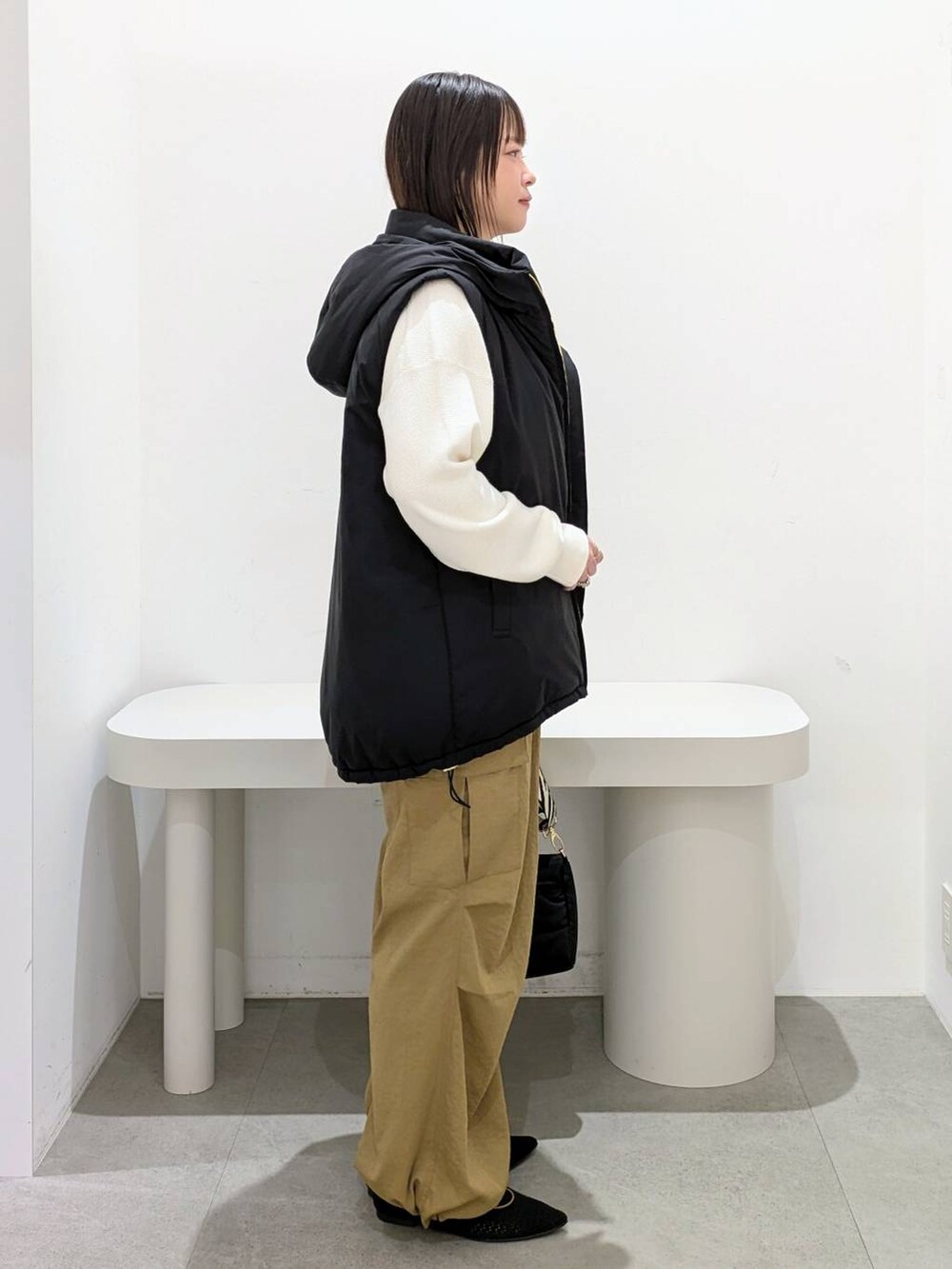ホワイト系のニット/セーター、イエロー系のカーゴパンツ、ブラック系のその他アウターを着用したレディースの秋コーディネートの5枚目の写真