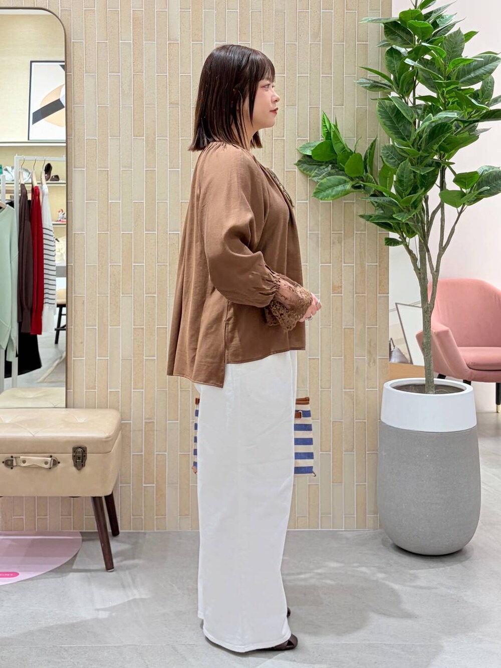 ホワイト系のデニムパンツ、ブルー系のトートバッグ、ブラウン系のパンプスを着用したレディースの春コーディネートの5枚目の写真