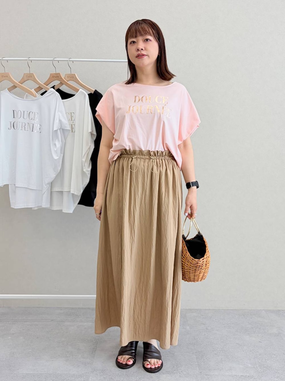 ブラウン系のかごバッグ、ピンク系のTシャツ/カットソーを着用したレディースの夏コーディネートの2枚目の写真